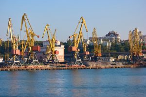 Wharf cranes with city background. Level luffing yellow cranes.