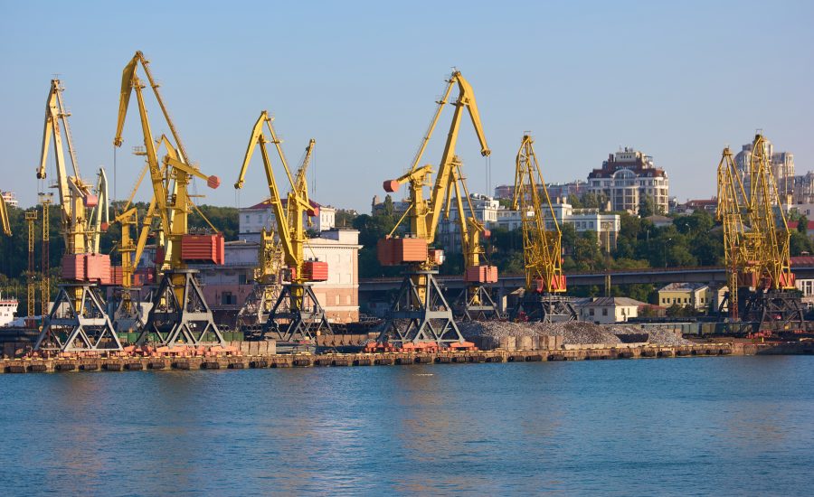 Wharf cranes with city background. Level luffing yellow cranes.